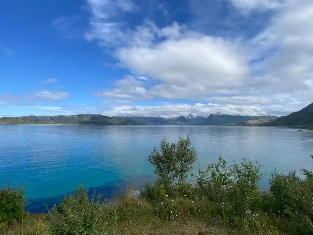 Calm blue water and low islands under a summer sky
