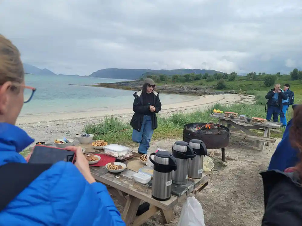 A guest at the picnic table with flasks and food