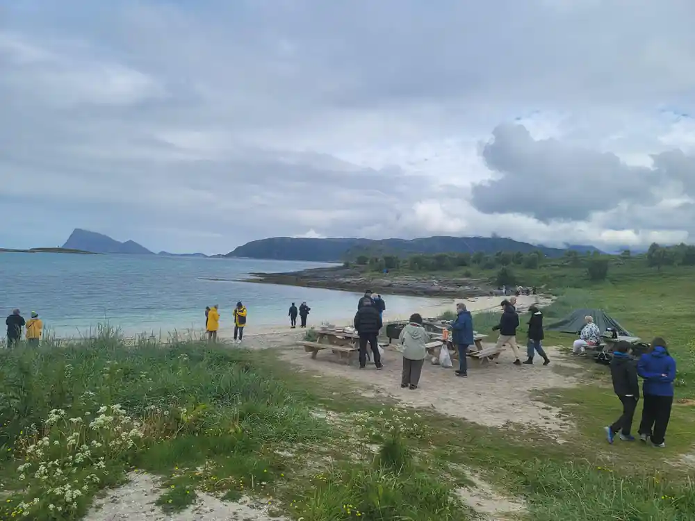 Guests gathered at picnic tables on the shore