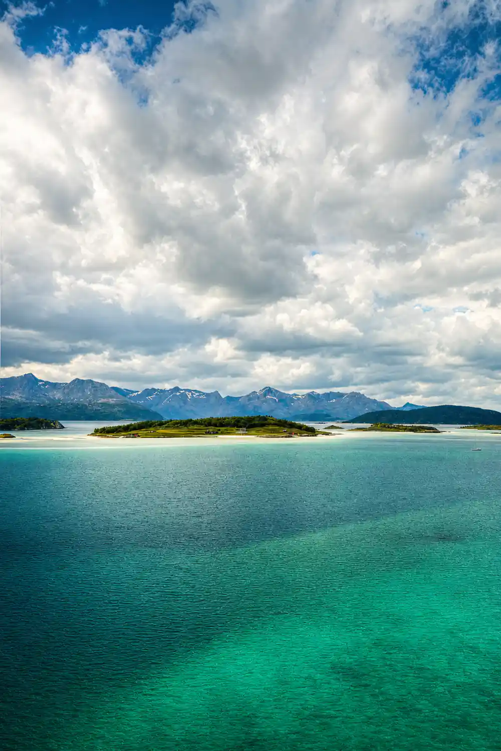 Low islands under heavy cloud across still water