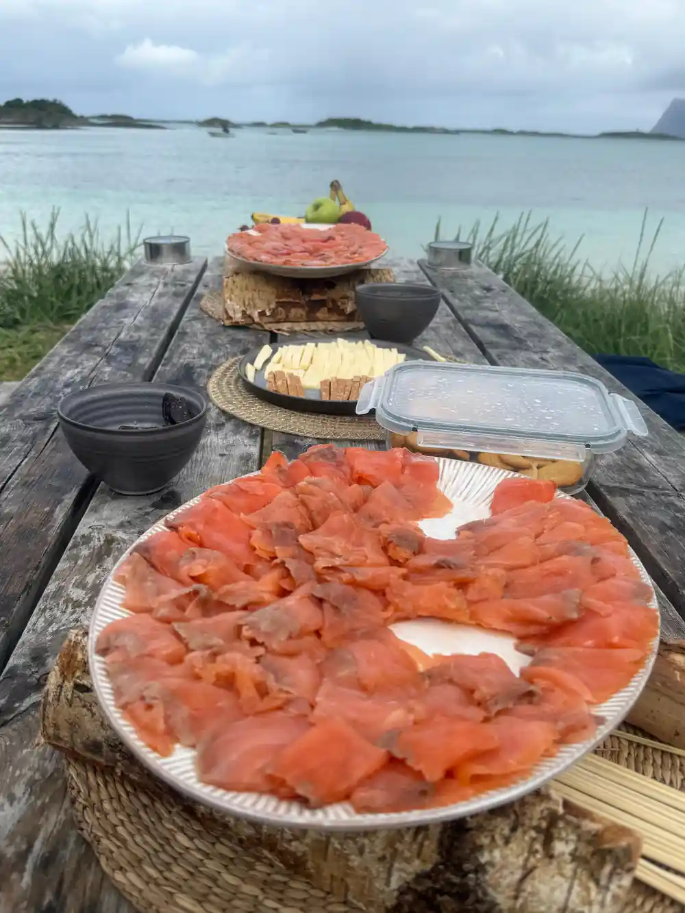 A platter of cured salmon on the picnic table by the sand