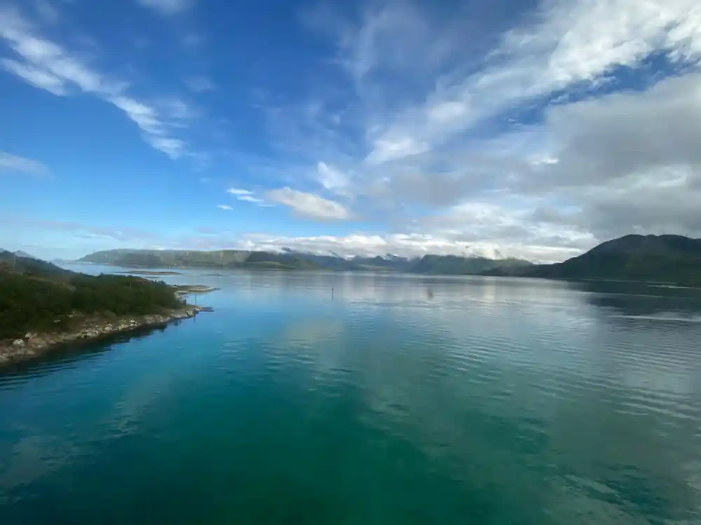Still turquoise water between low green shores